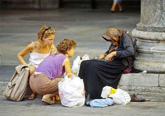 Mulheres ajudando velhinha moradora de rua