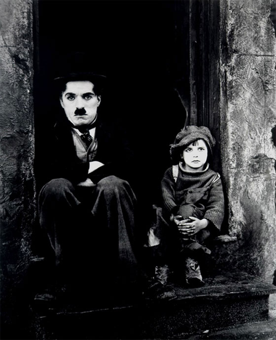 Jackie e Chaplin sentados no batente da porta