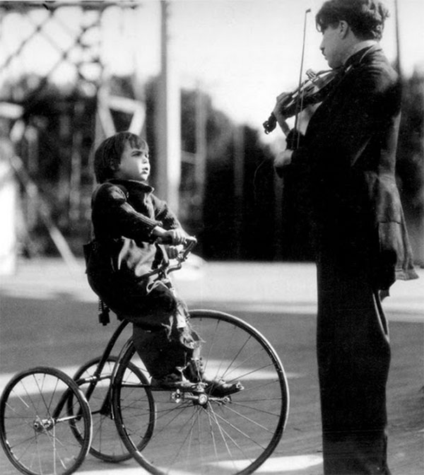 Jackie na bicicleta antiga e Chaplin no violino