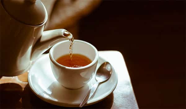 bule de chá servindo xicara de chá