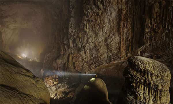 Explorador na caverna Son Doong com a lanterna ligada